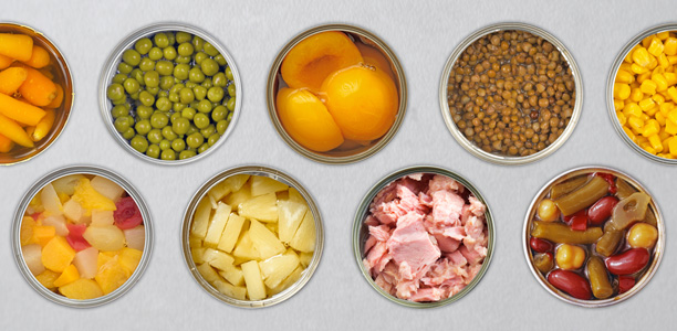 Top-down view of various opened cans of fish, fruit and vegetables