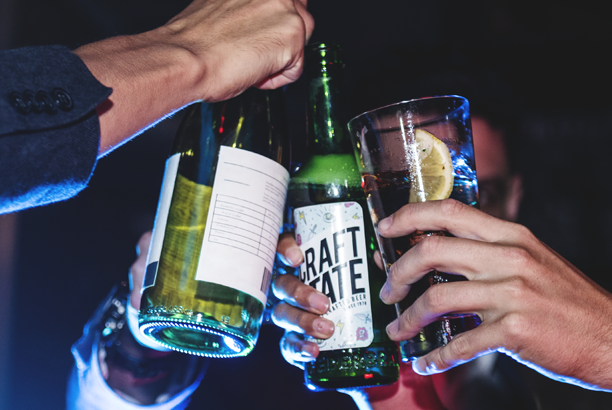 Several people toasting with various alcoholic drinks