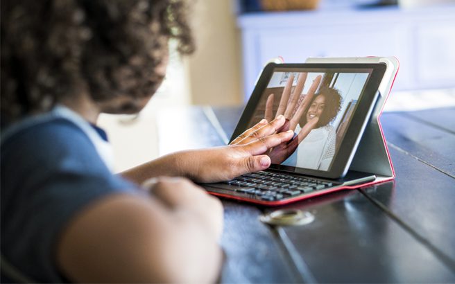 A child having an online video call with her mother