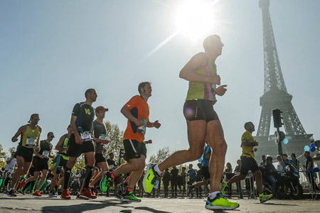 Runners in the Paris Marathon, passing the Eiffel Tower
