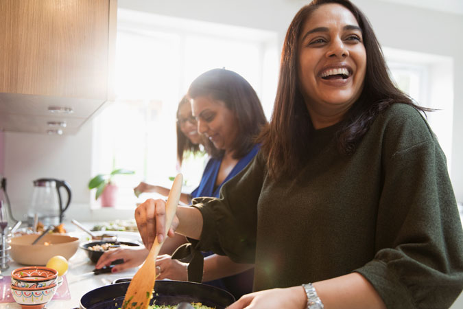 A group of people enjoying cooking in a kitchen