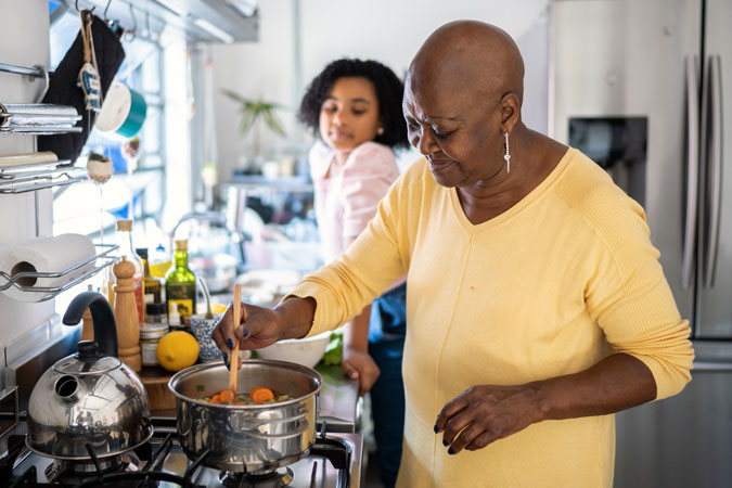 Girl helping grandmother cooking at home