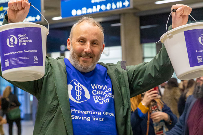 Geoff holding up fundraising buckets