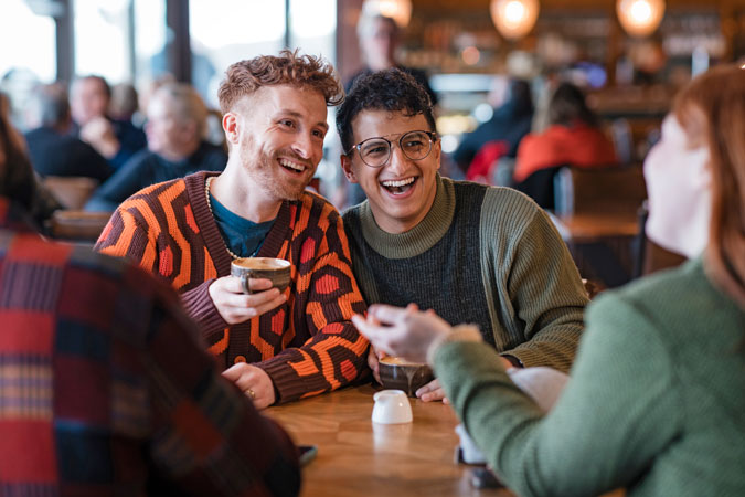 Younger men enjoy a coffee