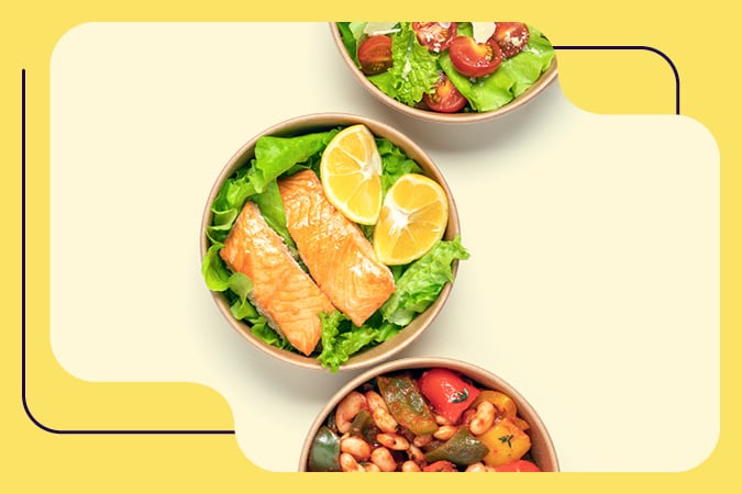Three bowls of food on a light background: one with salmon fillets and lemon on lettuce, one with salad of lettuce and cherry tomatoes, and one with a mixed bean and vegetable stew. Ideal for illustrating cancer prevention resources for health professionals.