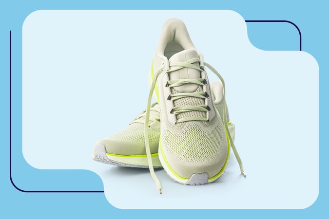 A pair of light green athletic trainers with white soles and yellow accents, styled against a light blue background with abstract shapes—an energetic image ideal for materials on cancer prevention resources for health professionals.