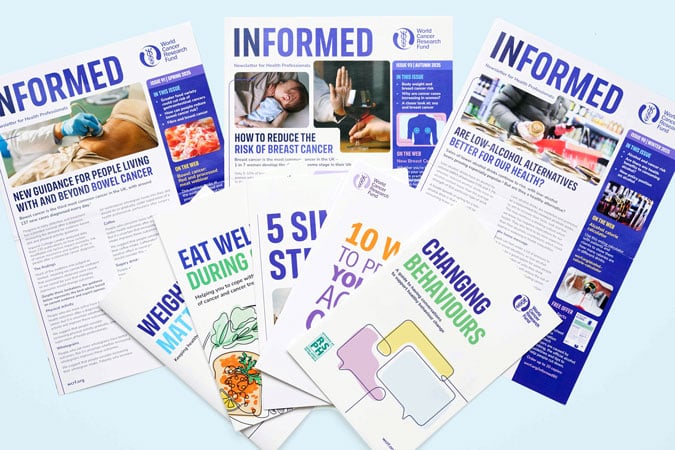 A collection of health information leaflets and newsletters from the World Cancer Research Fund, featuring topics such as cancer prevention workshops for health professionals, healthy eating, weight management, and reducing alcohol intake, arranged on a light blue surface.