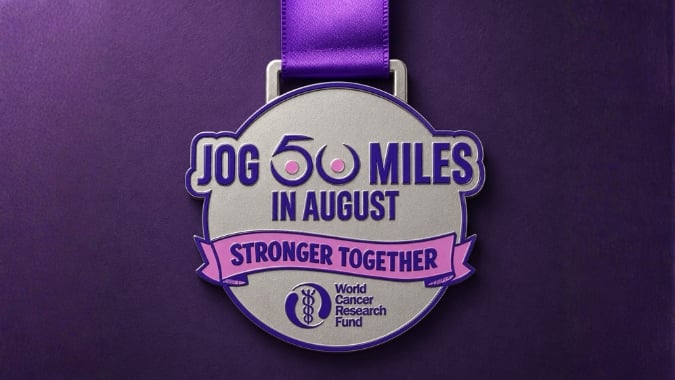 A silver medal with a purple ribbon reads Jog 60 Miles in August, Stronger Together and features the World Cancer Research Fund logo on a purple background.